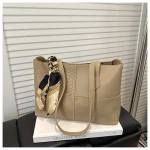 Detail of beige color-block tote bag with snakeskin texture and silk scarf handle