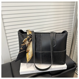 Detail of snake skin pattern stitching and silk scarf accessory on black tote bag