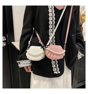 Detail of shell-shaped crossbody bags with pearl chains and textured PU leather finish