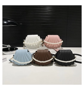 Detailed view of colorful shell-shaped crossbody bags with premium pearl chain straps