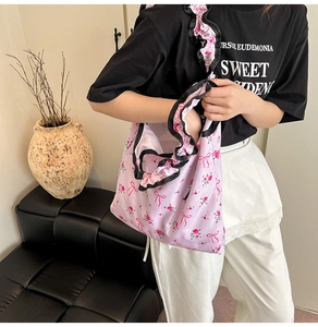 Dettaglio della borsa shopper rosa a fiori con rose e bordi increspati neri eleganti