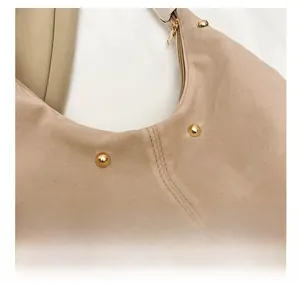 Vue détaillée du sac à main beige en toile avec rivets dorés et coutures précises