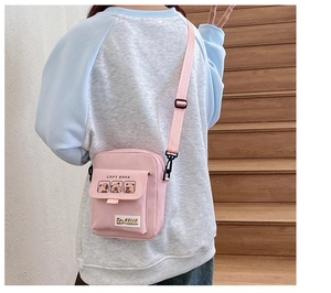 Detail of pink canvas crossbody bag with cute Capybara cartoon and adjustable strap