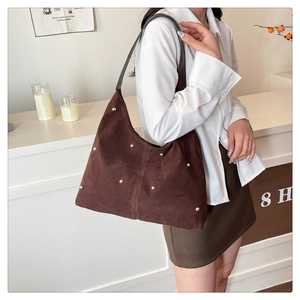 Détail du sac Hobo en daim marron foncé avec clous dorés et grande capacité de rangement