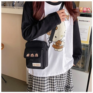 Close-up of black canvas capybara crossbody bag shown from a top-down model view