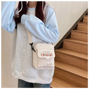 Detailed shot of white canvas crossbody bag featuring cute cartoon capybara prints