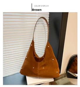 Detail view of brown suede tote bag featuring decorative gold rivets and textured finish