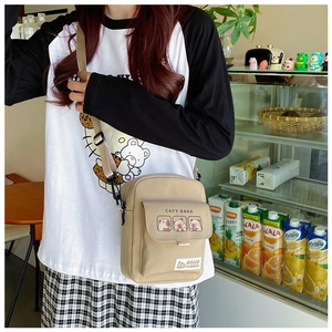 Close-up of khaki canvas crossbody bag with cute Capybara print and adjustable strap