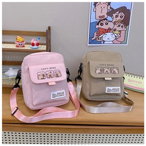 Detail of pink and khaki crossbody bags featuring a cute capybara print and nylon strap