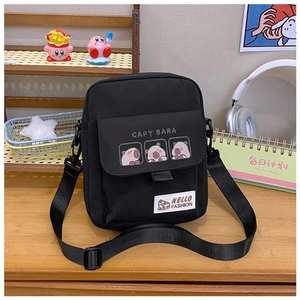 Detail of a black canvas crossbody bag featuring three cute cartoon capybara prints