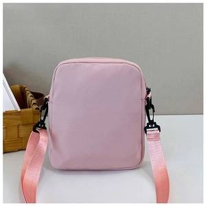 Detail of pink canvas mini crossbody bag with adjustable shoulder strap and black buckle