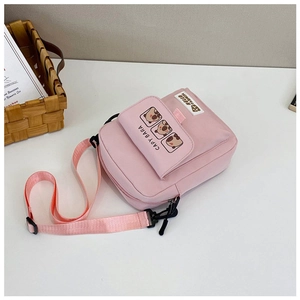 Detail of pink canvas bag featuring cartoon capybara prints and adjustable strap