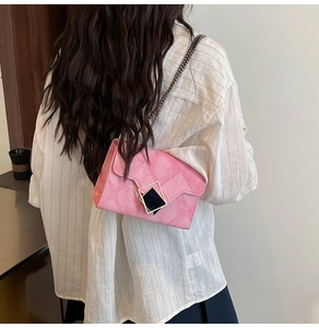 Détail du sac à bandoulière rose avec texture en losanges et fermoir géométrique