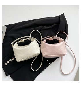 Detail of elegant white and pink leather tote bags with grid stitching and gold hardware