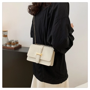 Detail of off-white crocodile embossed crossbody bag with iconic gold H-shaped buckle