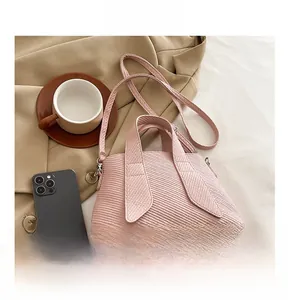 Detailed view of pink textured tote bag with top handles and detachable shoulder strap