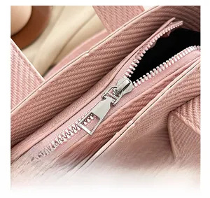Close-up of silver metal zipper detail and woven texture on a pink bucket bag