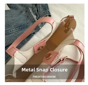 Détail de la garniture en cuir rose et du fermoir magnétique sur le sac en toile