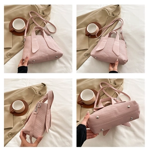 Detail view of pink corduroy bucket bag showing texture, silver hardware and base studs
