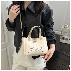 Détail du sac seau en PU blanc crème avec motifs ours et bandoulière amovible