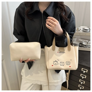 Détail d'un ensemble cabas crème avec imprimé ours et pochette zippée à la main