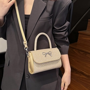 Sparkling champagne gold mini crossbody bag with metallic bow detail for women