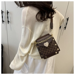 Detail of a dark brown square crossbody bag with letter print and golden heart lock