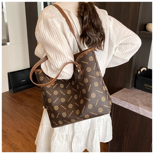 Detailed close-up of retro large tote bag with floral pattern shown on model's shoulder