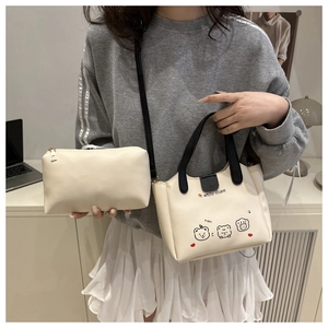 Détail du sac seau en similicuir crème avec imprimé ours mignon et pochette zippée assortie