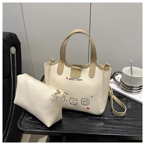 Détail du lot de deux sacs fourre-tout crème avec imprimé chiot et détails dorés