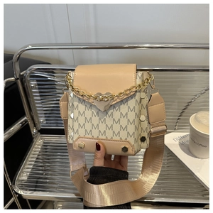 Close-up of heart-shaped gold buckle and M-letter print on stylish mini square bag