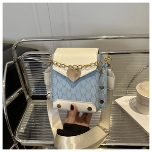 Detail of blue and white contrast square bag with golden heart lock and chain handle