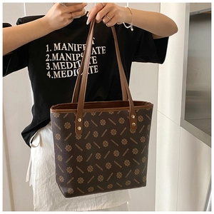 Close-up of vintage dark brown tote bag featuring floral patterns and faux leather texture