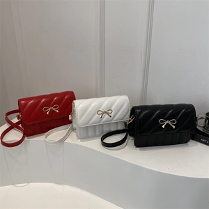 Quilted underarm bag with metal bow in red, off-white, and black minimalist style