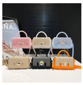 Collection de petits sacs carrés colorés avec boucle dorée présentés en six teintes variées