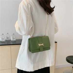 Chic green stone pattern crossbody bag with gold buckle shown on female model shoulder