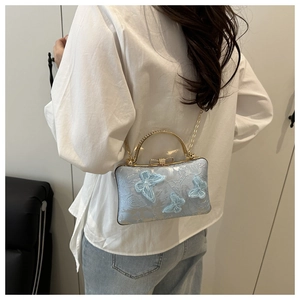 Close-up of light blue embroidery bag with 3D butterflies and elegant gold chain strap