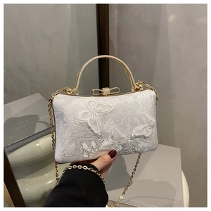 Detail of white evening clutch with 3D butterfly embroidery and gold metal handle