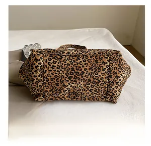 Vue détaillée du fond robuste et de la toile résistante à motif léopard du sac fourre-tout