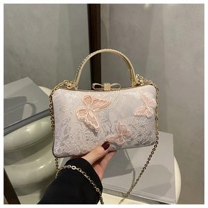 Detail of pink lace clutch bag with 3D butterfly appliques and diamond-set handle
