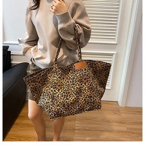 Détail du cabas en toile léopard avec boutons-pression latéraux et patch cuir
