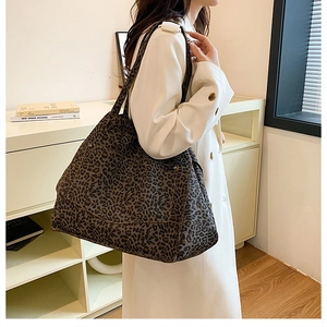Détail d'un grand sac cabas en toile léopard avec poche avant et coutures apparentes