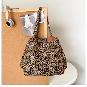 Détail du sac cabas en toile à imprimé léopard avec des anses en cuir marron chic