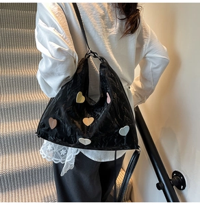 Detail of black wrinkled tote bag featuring colorful macaron heart-shaped patches