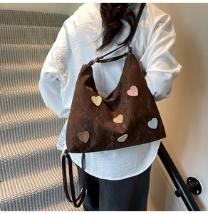 Detail of a brown PU tote bag with colorful 3D heart patches and metal strap buckle