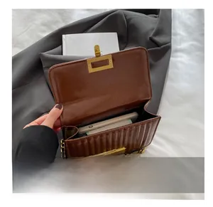 Détail de l'intérieur du sac en cuir marron montrant l'espace pour téléphone et portefeuille