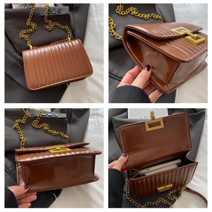 Détail du sac à bandoulière marron avec surpiqûres verticales et chaîne dorée