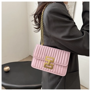Detail of light pink quilted leather texture with gold geometric lock and chain strap