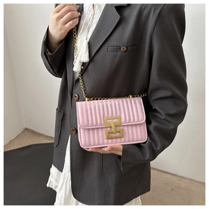 Detail of pink quilted crossbody bag with golden chain and metallic buckle