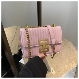 Close-up of pink quilted crossbody bag featuring vertical stitching and a gold metal buckle